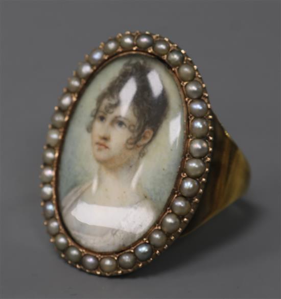 An early 20th century yellow metal and split pearl set portrait miniature ring (adapted), size V.